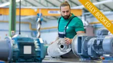 A technician inspects a progressing cavity pump in a workshop setting during a practical training session for pump maintenance.
